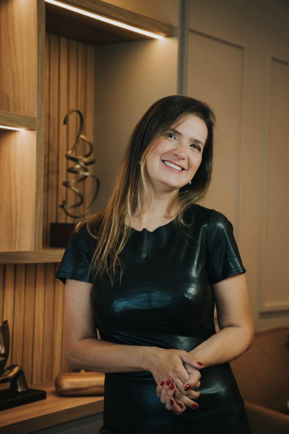 Dra. Aline Dalmazo sorrindo em seu consultório
