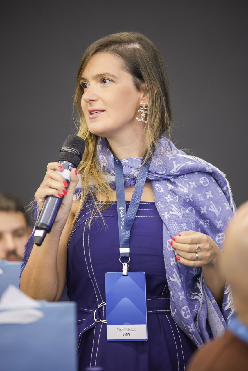 Dra. Aline Dalmazo palestrando com microfone